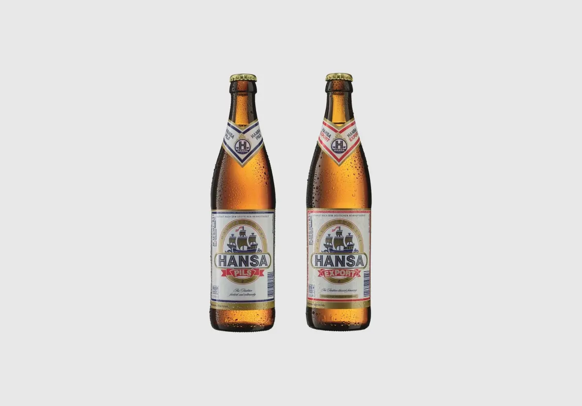 Zwei Bierflaschen stehen nebeneinander auf einem weißen Hintergrund. Sie sind mit kühlem Kondenswasser bedeckt.